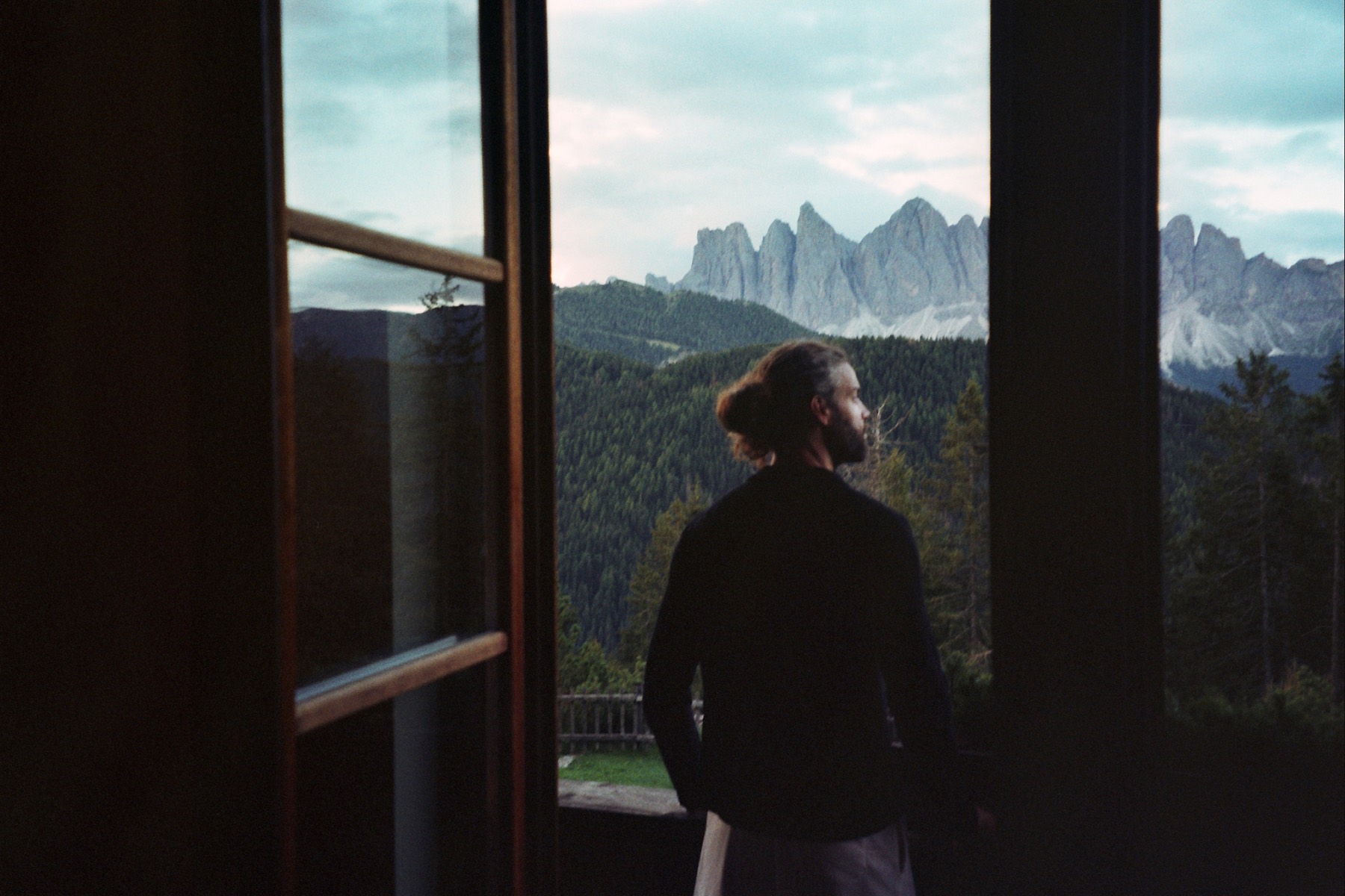 The Odle peaks of the Dolomites seen from a mountain lodge window at dusk